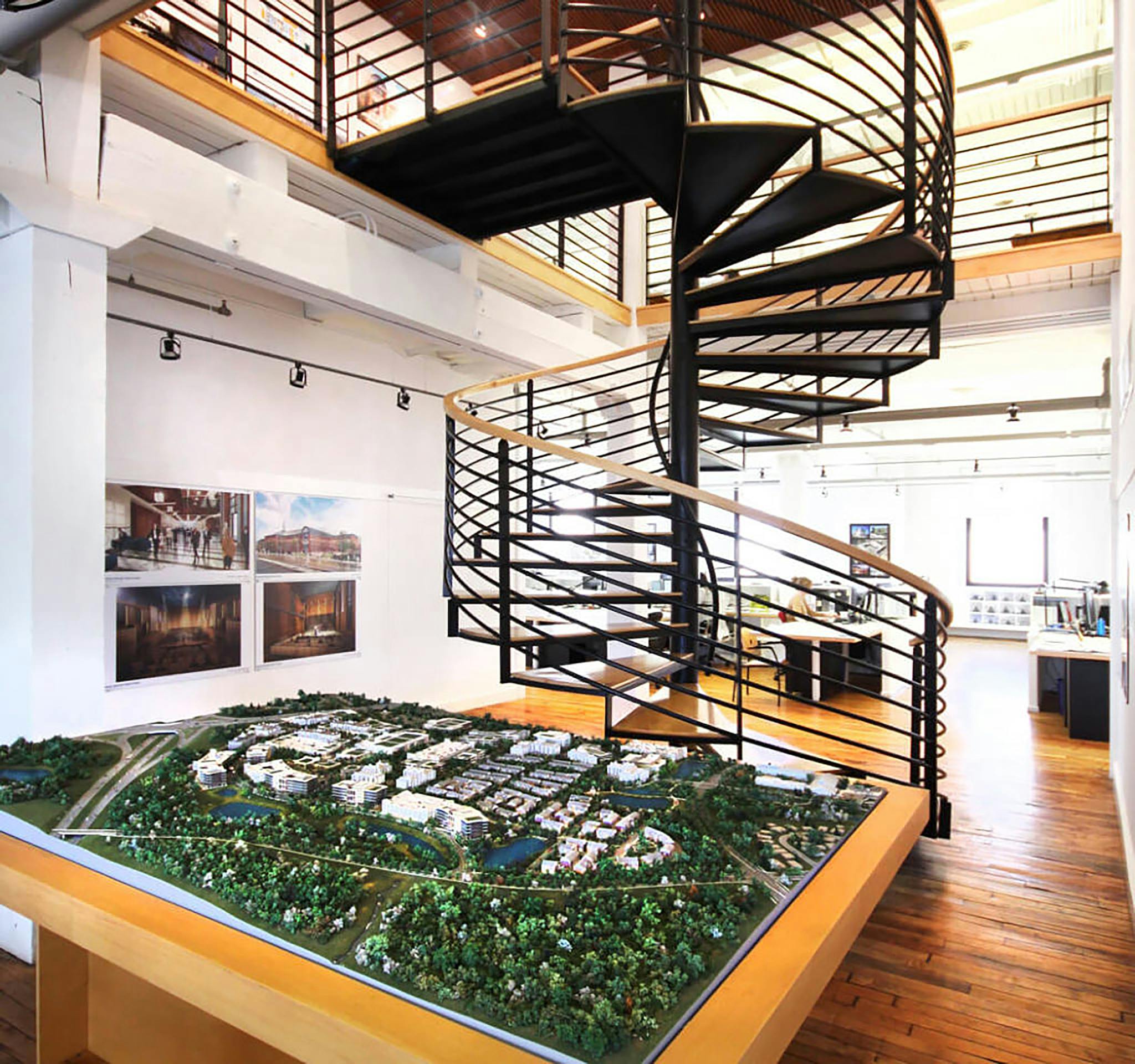 an office with architectural modal and spiral staircase